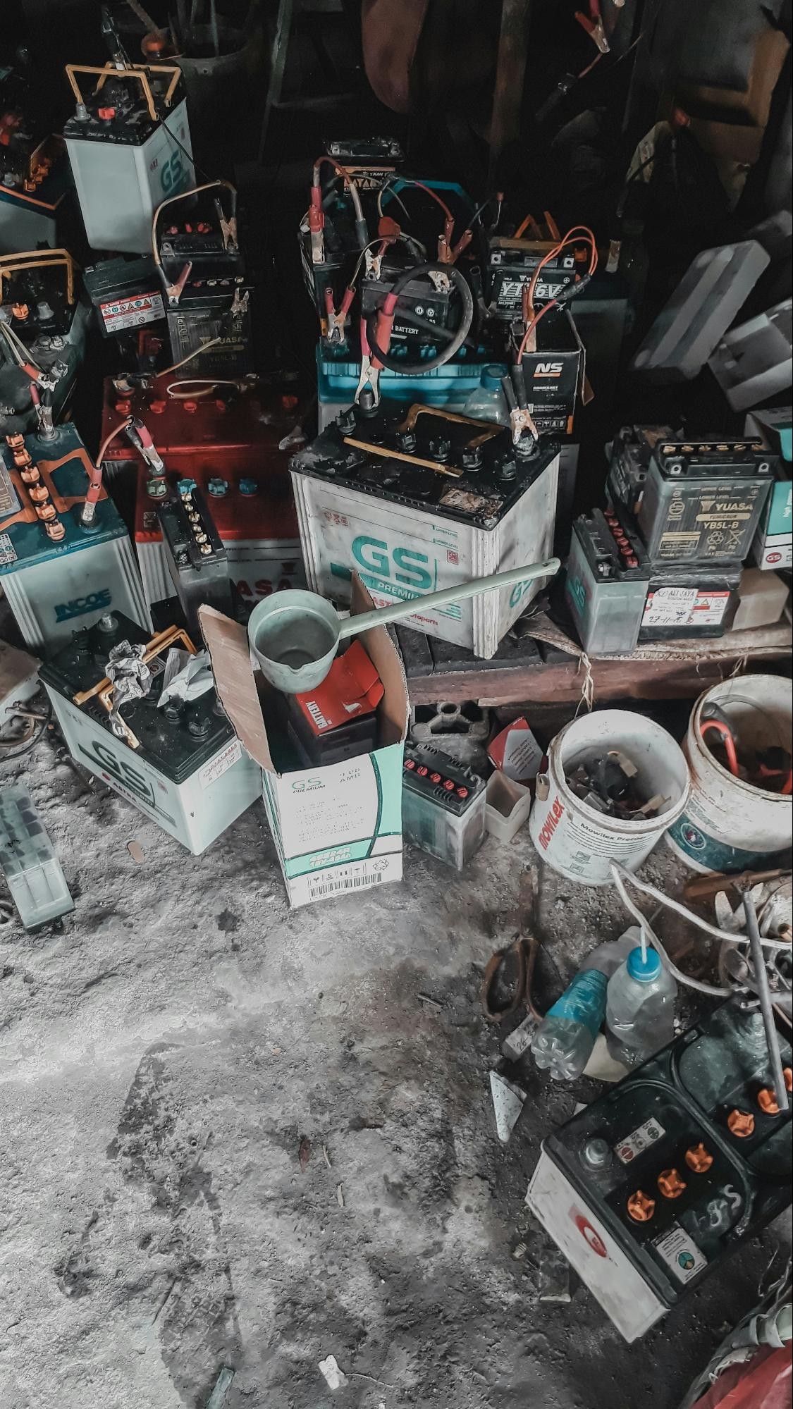 A collection of lead-acid batteries and related equipment in a workshop