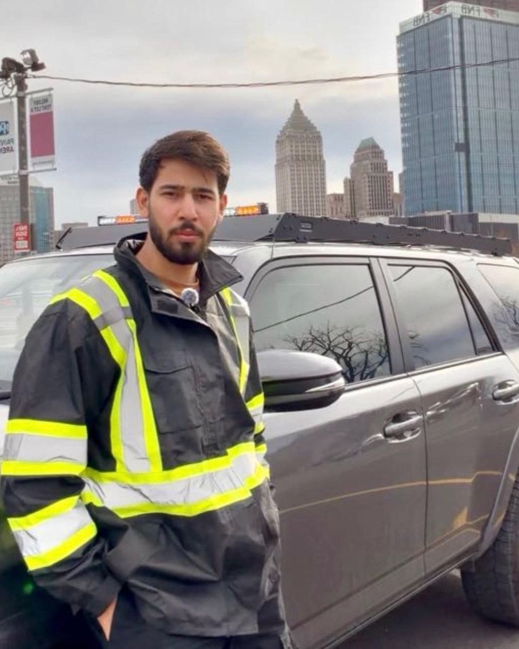Hassan, owner of Roadmate Services, in a hi-vis jacket next to the grey Roadmate service truck