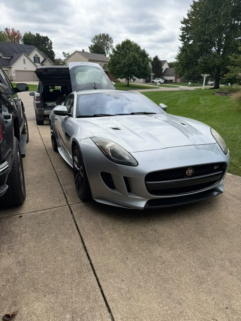 Silver Jaguar F-Type parked in a home driveway with its rear hatch open during a roadside call