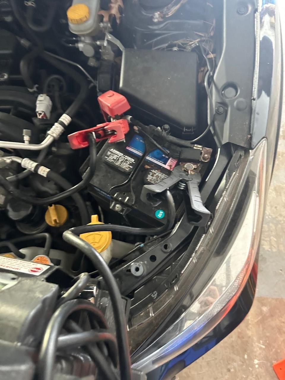 Jump clamps connected to both terminals of the battery in an engine bay