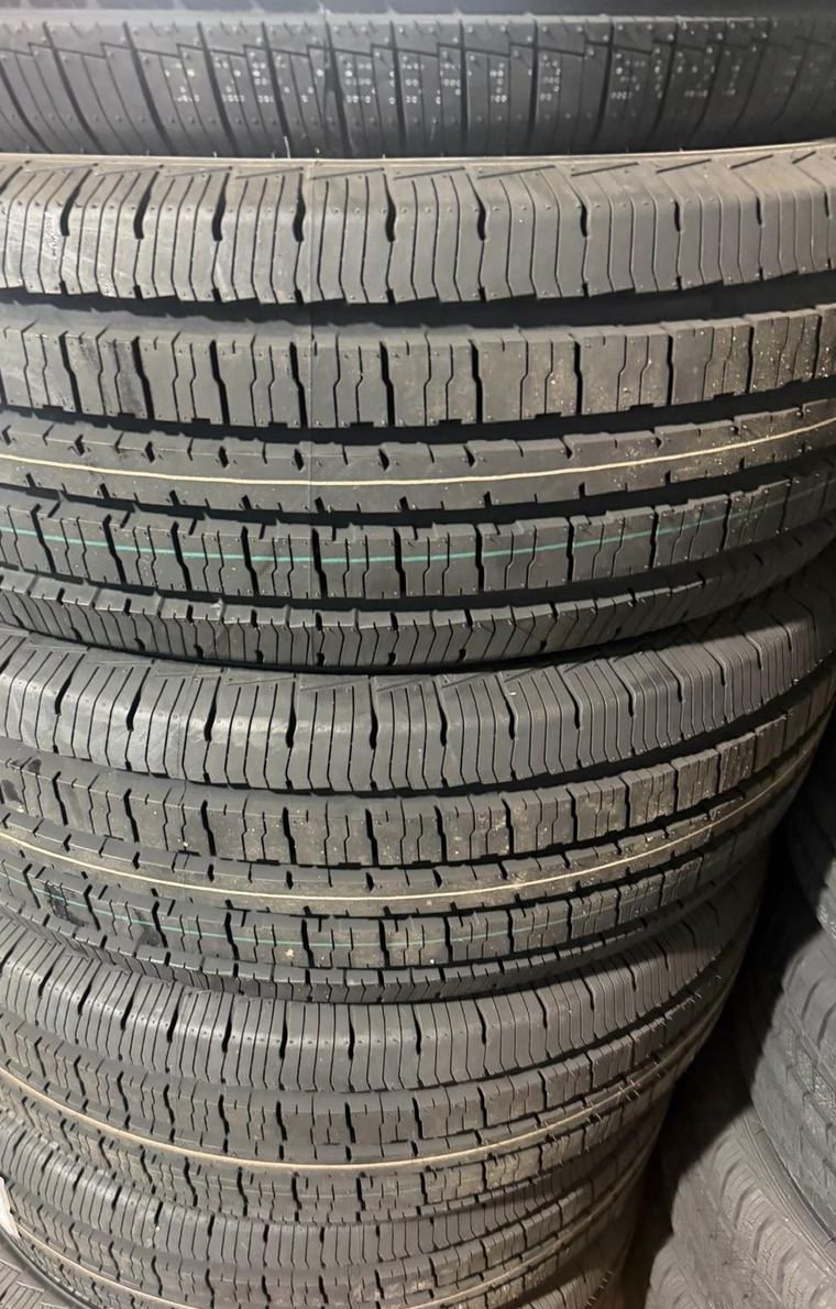 Stack of new, unused car tires with fresh tread standing in a tire store