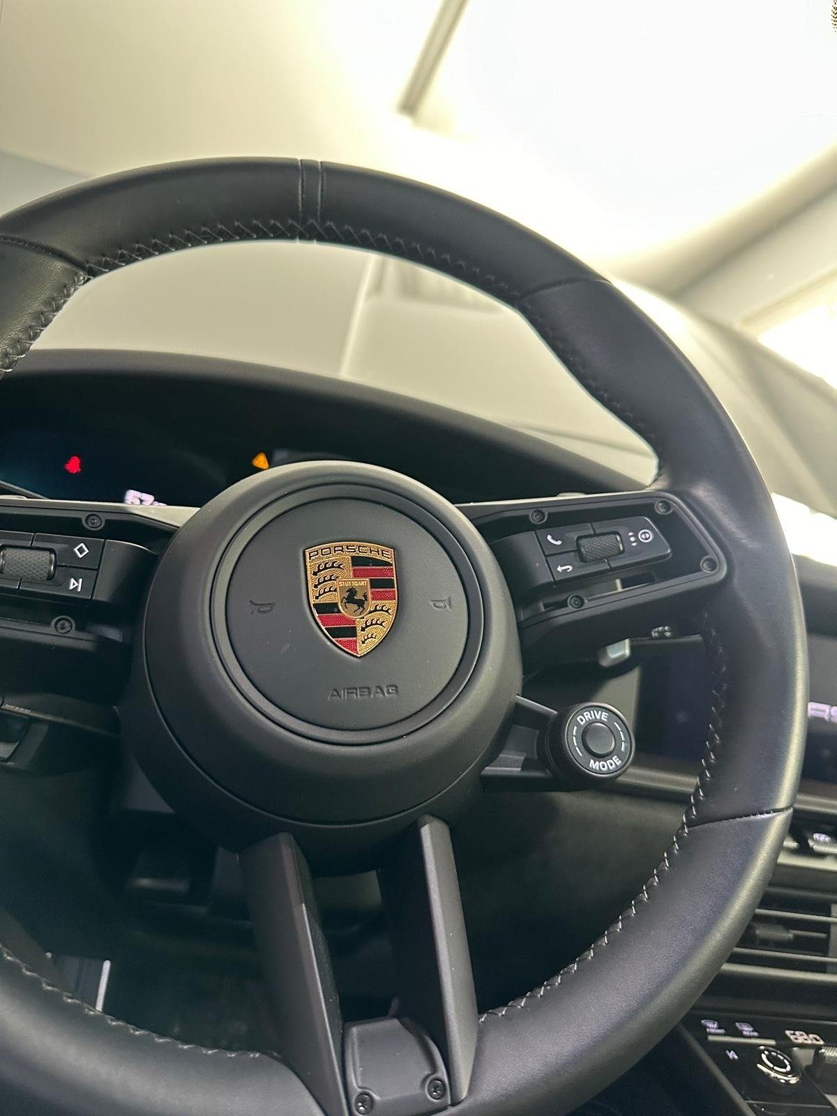 Porsche steering wheel and instrument cluster seen from the driver seat