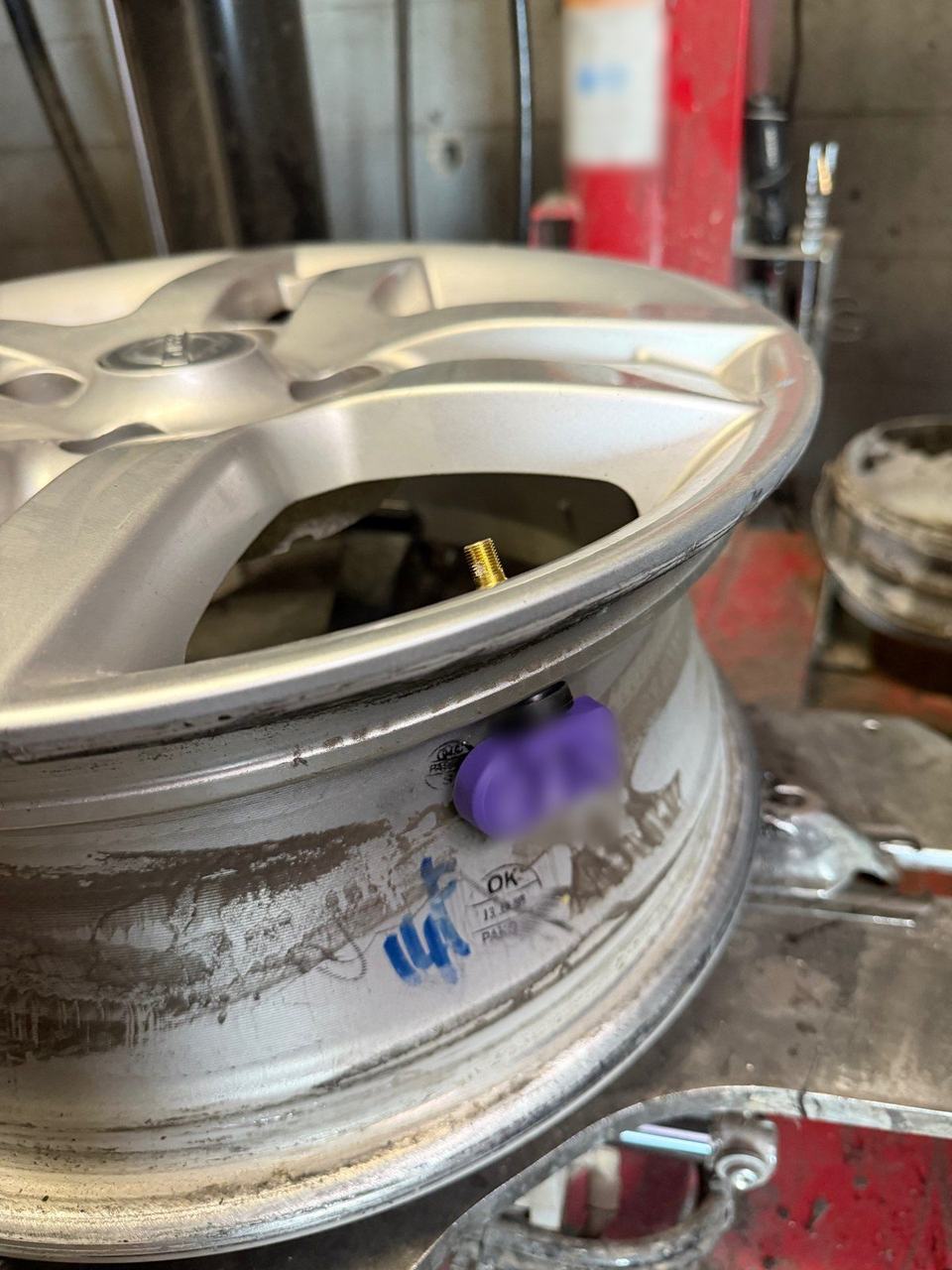 New TPMS sensor valve fitted inside the rim on a tire changer